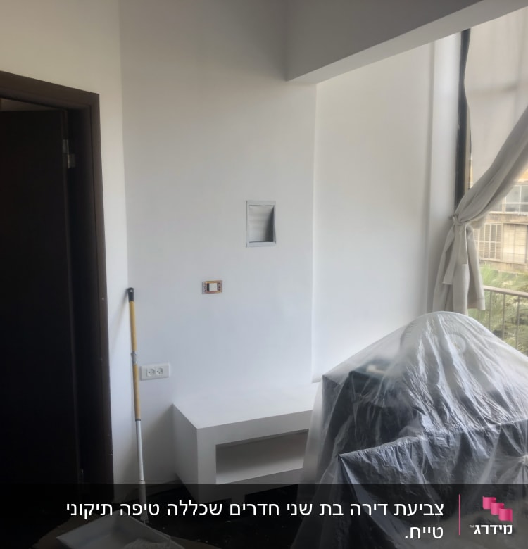 חדר עם קיר צבוע, רולר ומגש צבע